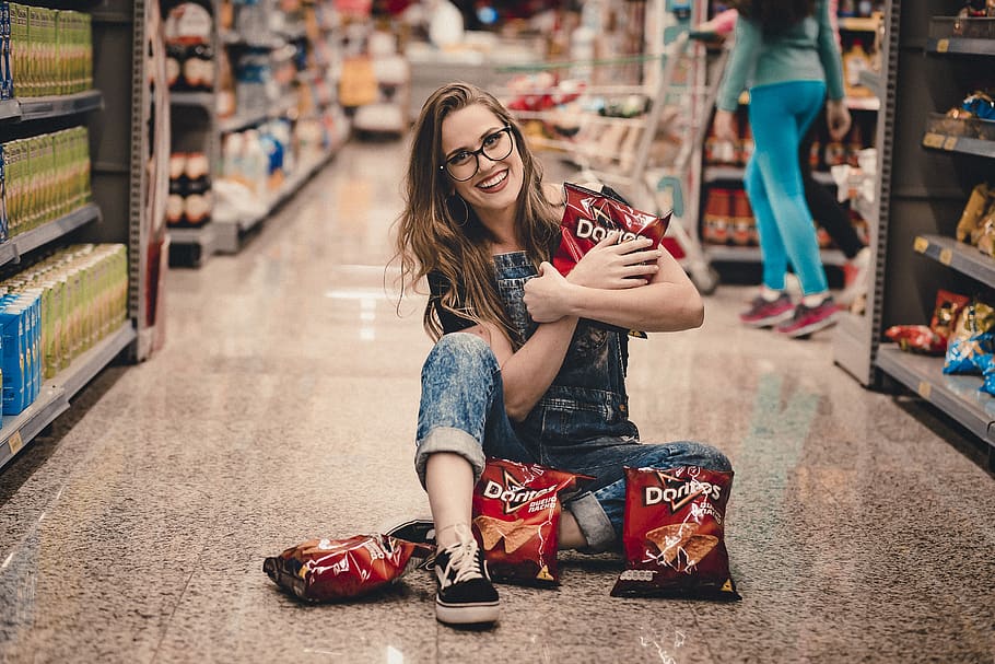 Photo of Smiling Woman Sitting in the Middle of Shopping Aisle Holding Dorito Chips, HD wallpaper
