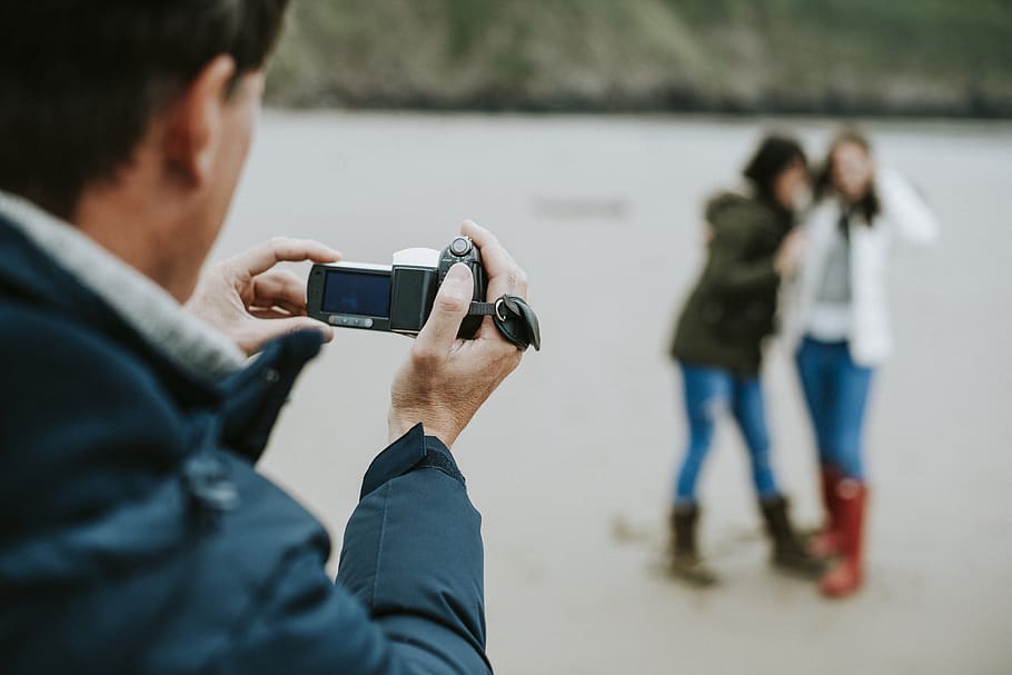 Man Taking Photo of Two Women Standing, blurred background, daylight HD wallpaper