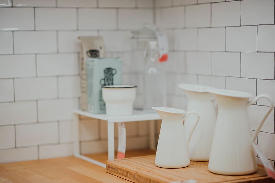 three white ceramic kettles on brown wooden board, hardwood, jug