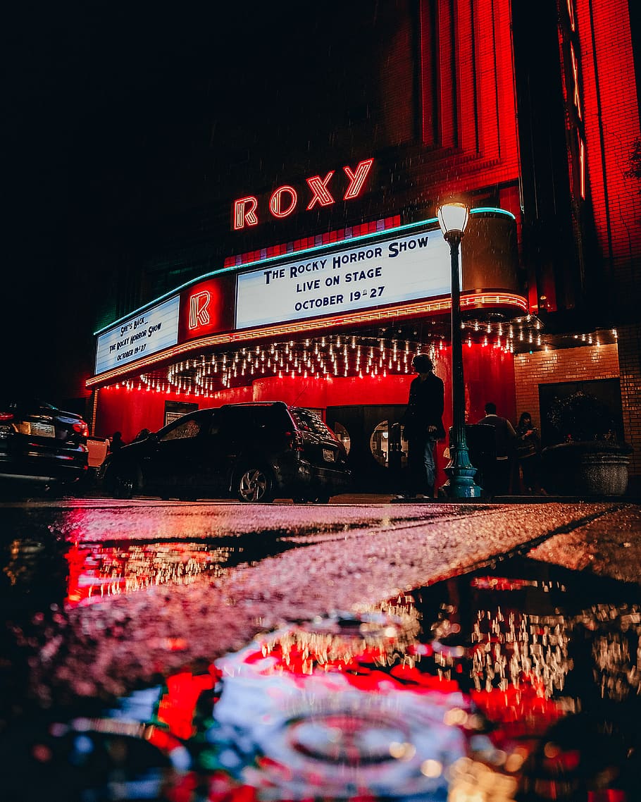 Roxy theater during rainy day, illuminated, water, text, night