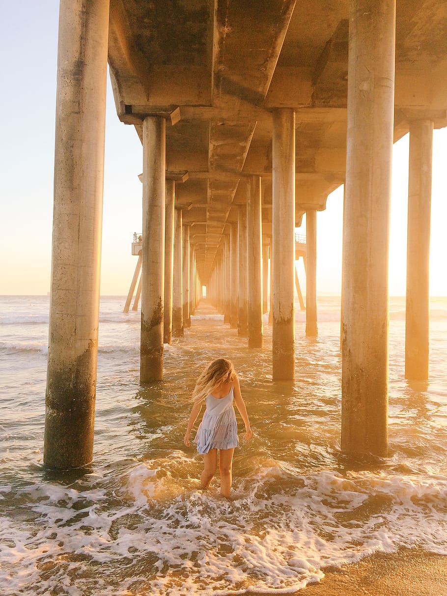 woman walking under dock, water, sea, rear view, one person, architectural column HD wallpaper