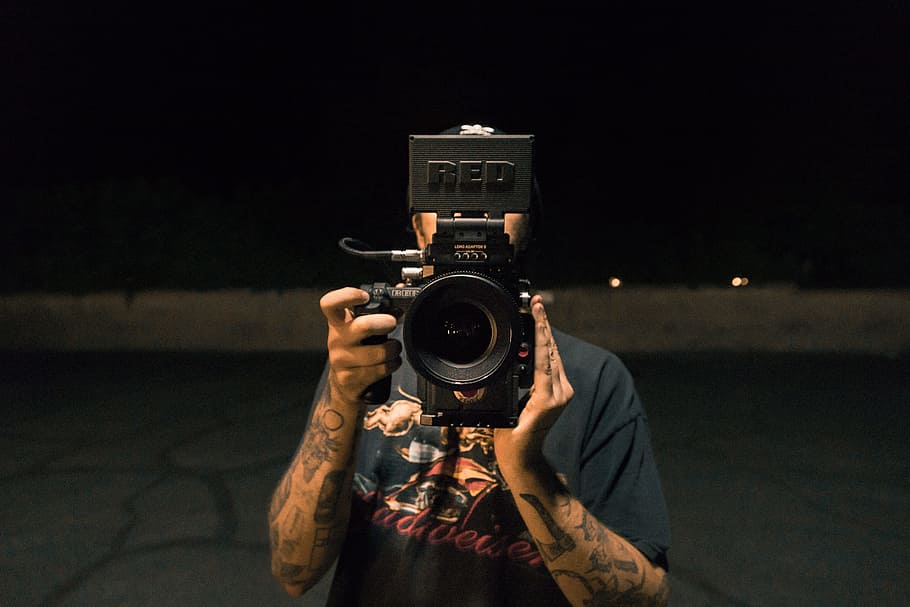 person holding video camera, filmmaking equipment, film camera