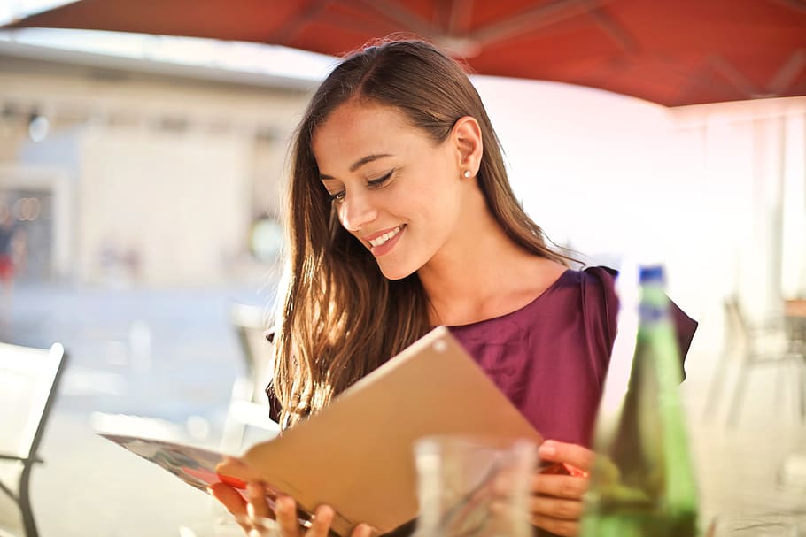 A young blonde woman purple red dress looking at a restaurant menu HD wallpaper