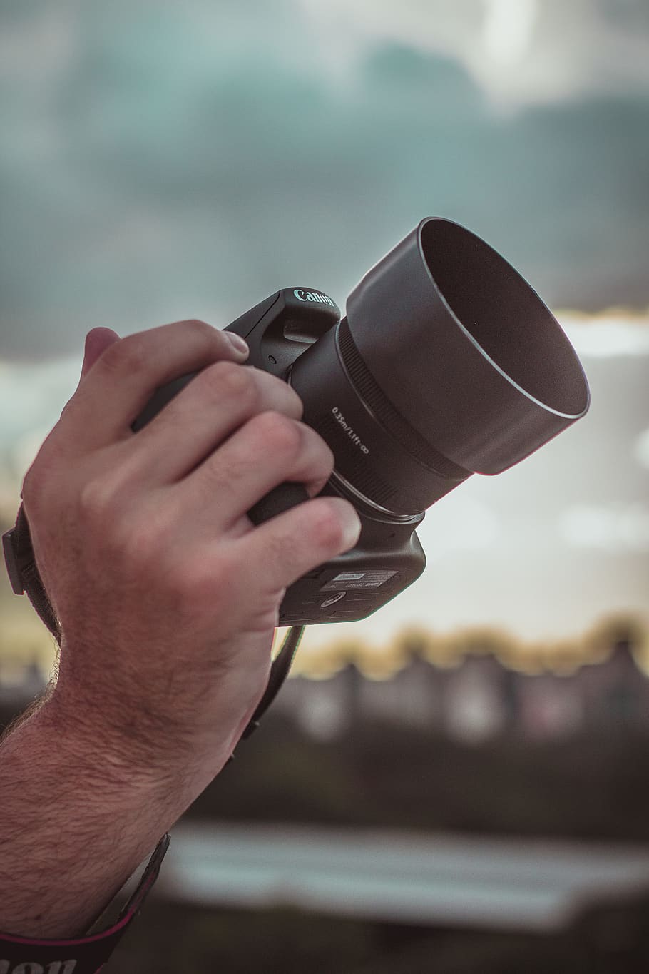 Person Holding Canon Dslr Camera, blurred background, camera lens