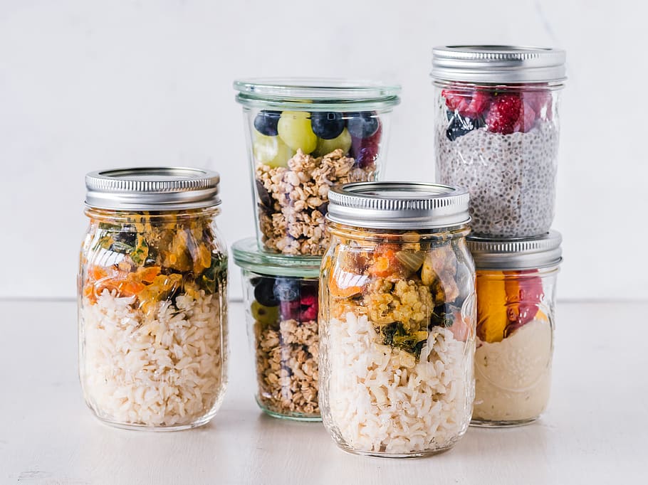 six full clear glass jars on white surface, food, snack, plant