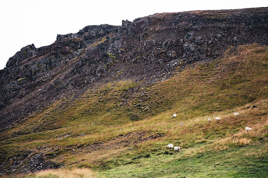 Crumbling rocky cliffs of a moss-grown hill, clouds, edge, erosion HD wallpaper