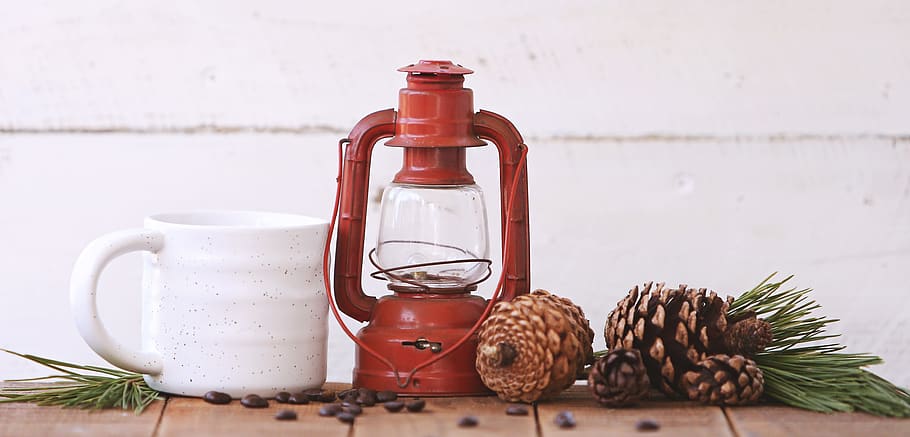 Red Kerosene Lantern Beside White Ceramic Mug on Brown Wooden Table HD wallpaper