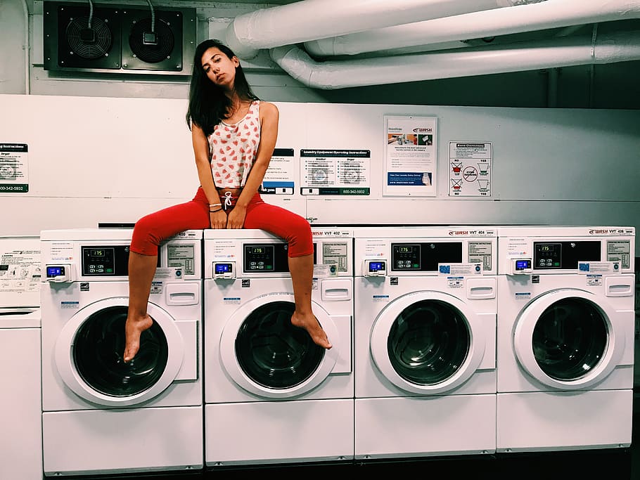 several washing machines, machinery, one person, laundromat, lifestyles