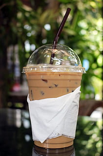 Cup of iced coffee outside on a table in a tropical garden, summer HD wallpaper