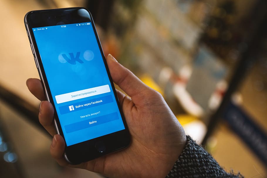 Display with login to the social network Vkontakte on modern smartphone in hands HD wallpaper