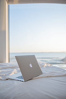 silver MacBook on white bed, laptop, window, computer, sea, ocean HD wallpaper