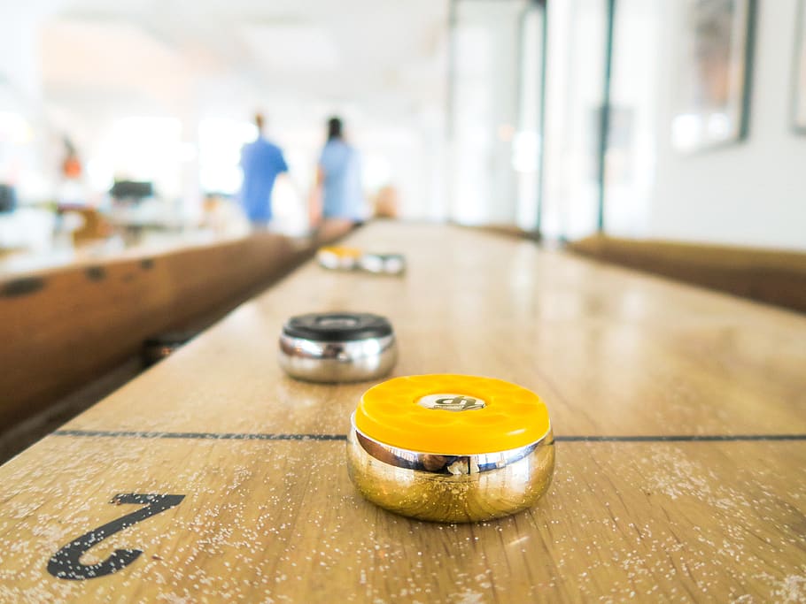 two black and yellow trinkets on table, indoors, focus on foreground HD wallpaper