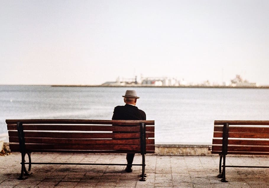 man sitting in brown wooden bench, analogue, film, cinematic