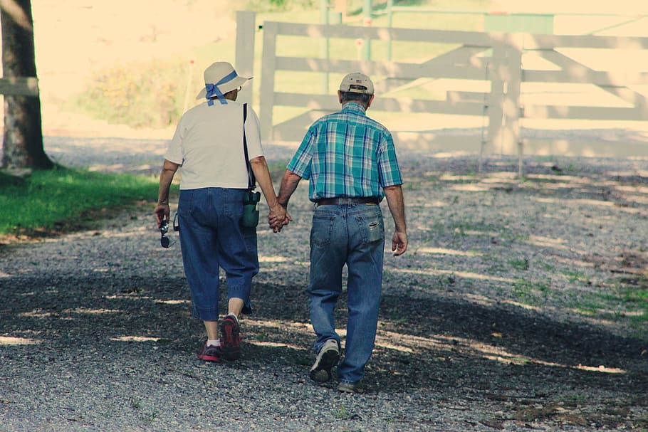 Old Couple Walking While Holding Hands, adults, cap, daylight