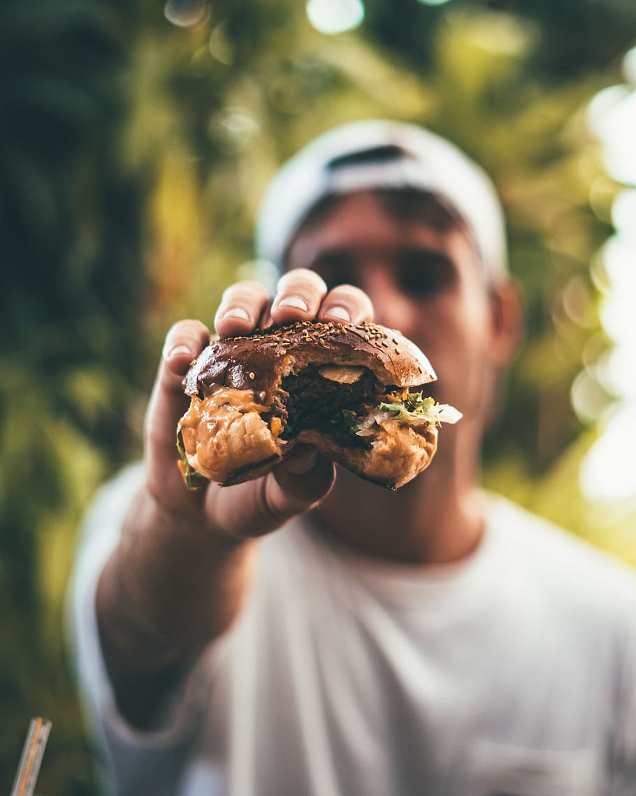 Photo of Person Holding Burger, adult, beef, bite, blurred background HD wallpaper