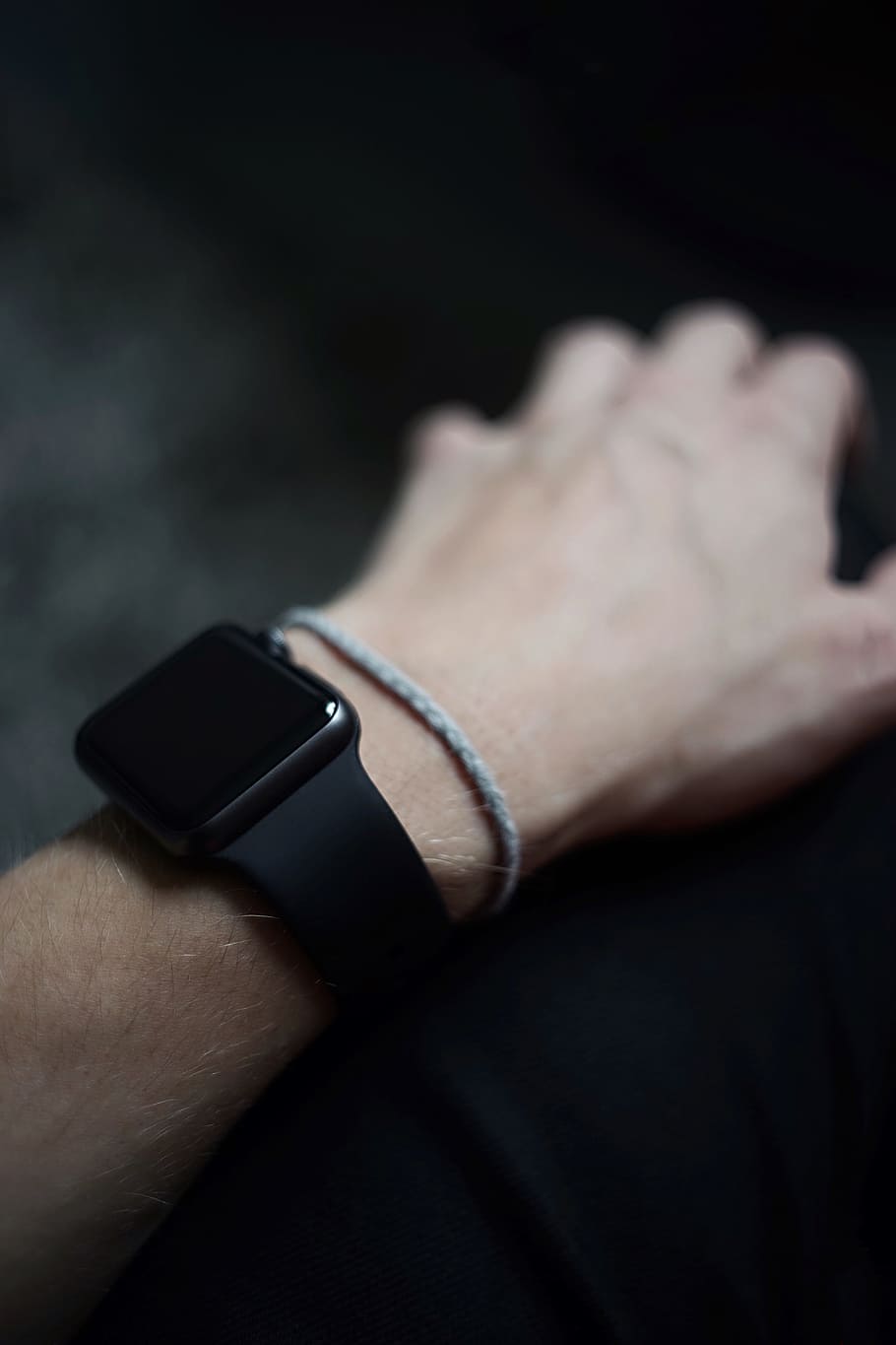 man wearing space gray Apple Watch with black Sports Band, wrist