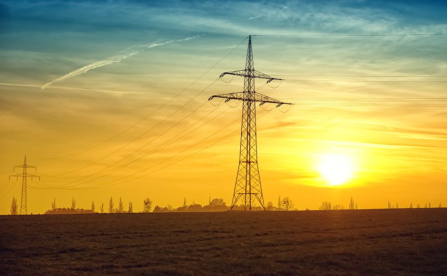 Brown Transmission Towers on Field during Sunset Landscape Photography HD wallpaper