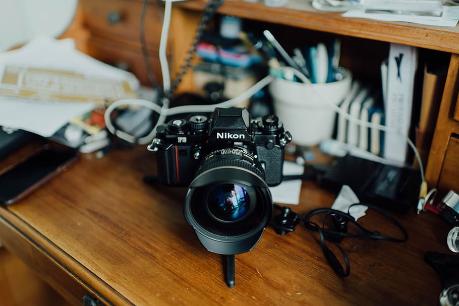 black Nikon camera on brown surface, lens, table, wooden, bokeh HD wallpaper