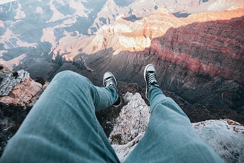 A top view of adventurer s legs dangled over canyon edge, landscape HD wallpaper