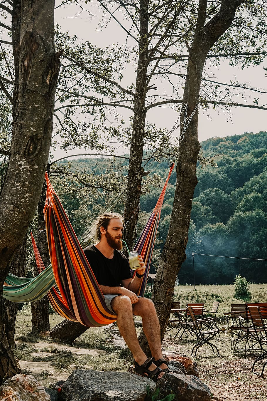 man sitting on hammock while drinking during daytime, furniture HD wallpaper