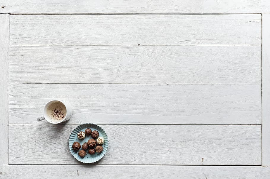 White Mug Filled With Coffee Beside Baked Pastries on Paper Plate All on Top of White Wood Surface HD wallpaper