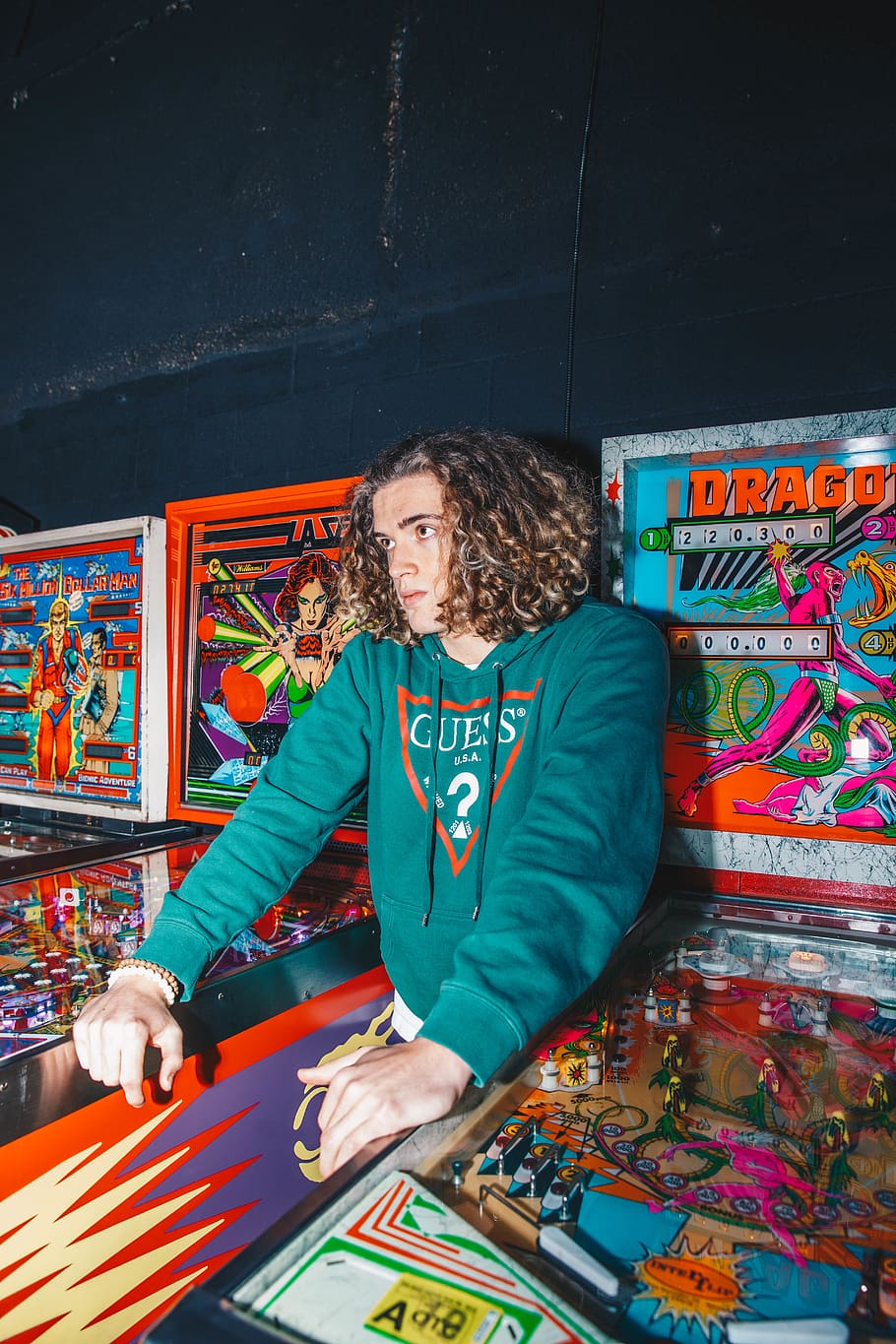 man standing between pinball games, arcade game machine, person HD wallpaper
