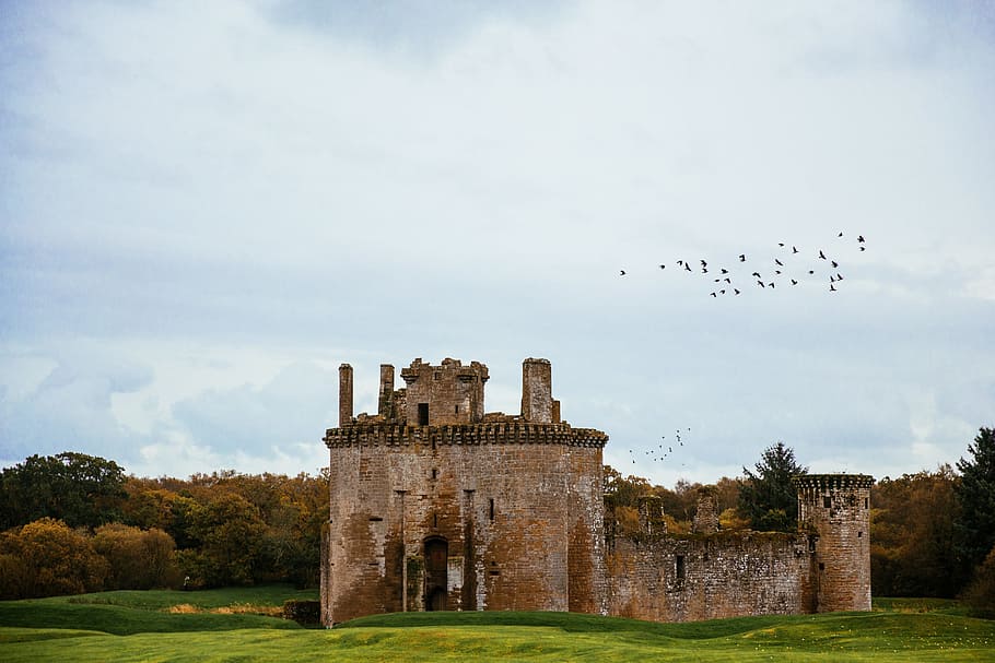 Birds flying over Caerlaverock Castle located on the southern coast of Scotland
