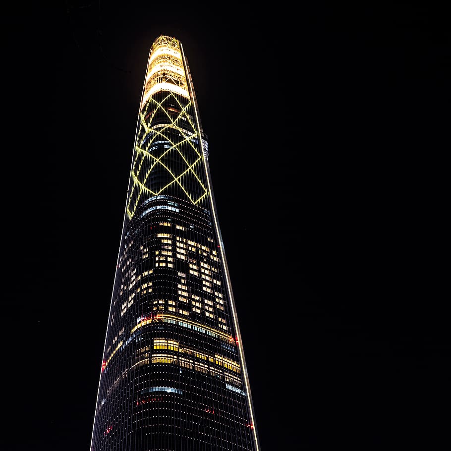 low angle photography of lighted curtain glass tower during nighttime