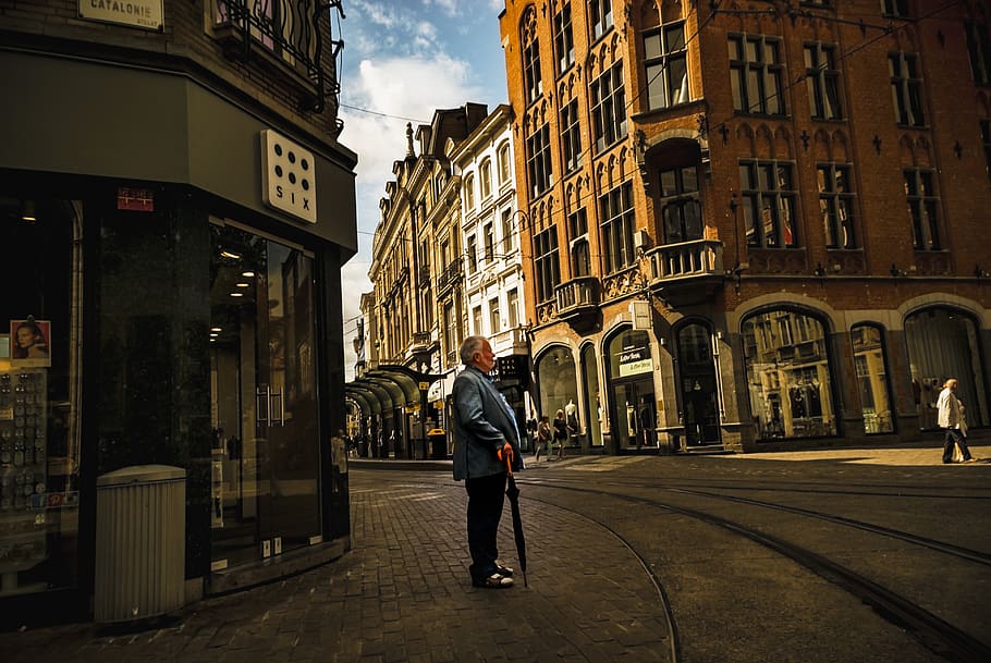 Man Holding Umbrella, architecture, buildings, clouds, commerce HD wallpaper