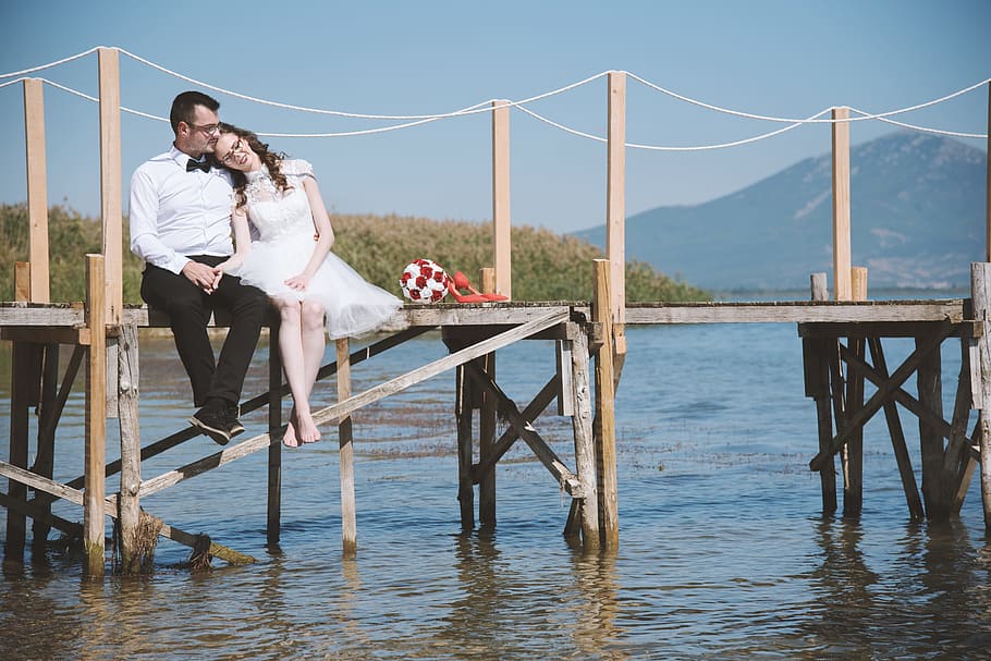 Photo of Couple Sitting On Dock, adults, affection, bridge, dress HD wallpaper
