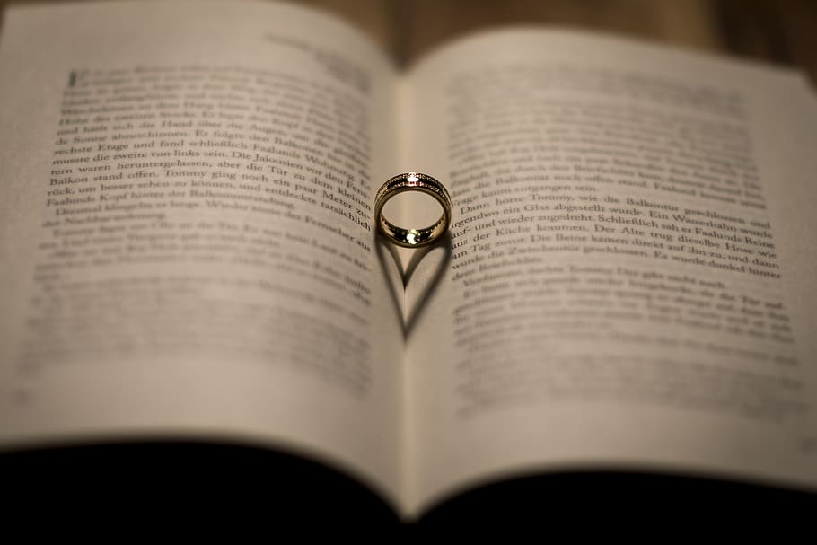 Selective Focus Photography of Silver-colored Ring on Opened Textbook HD wallpaper