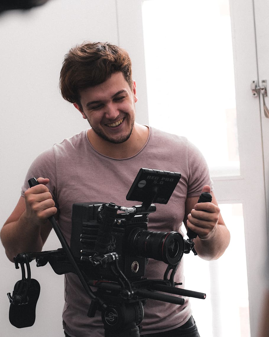 man standing beside DSLR camera, person, human, electronics, video camera HD wallpaper