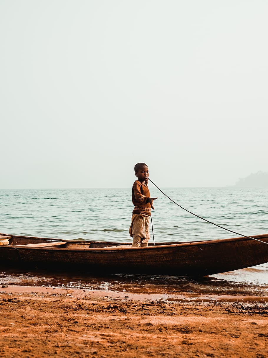 boy standing in boat while holding rope, water, sea, real people HD wallpaper