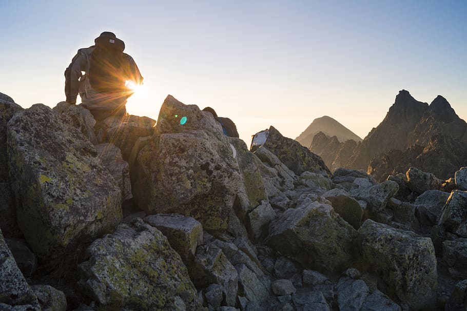 Person Sitting on Gray Rocks Under Clear Blue Sky, man, mountains HD wallpaper