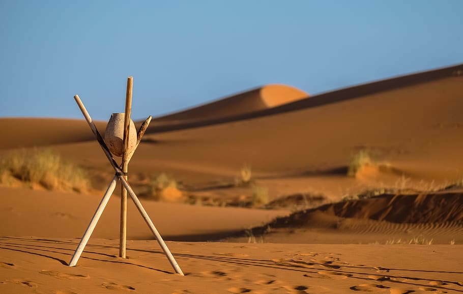 Brown Stone on Tripod Sticks at a Desert, bushes, daylight, footprints HD wallpaper