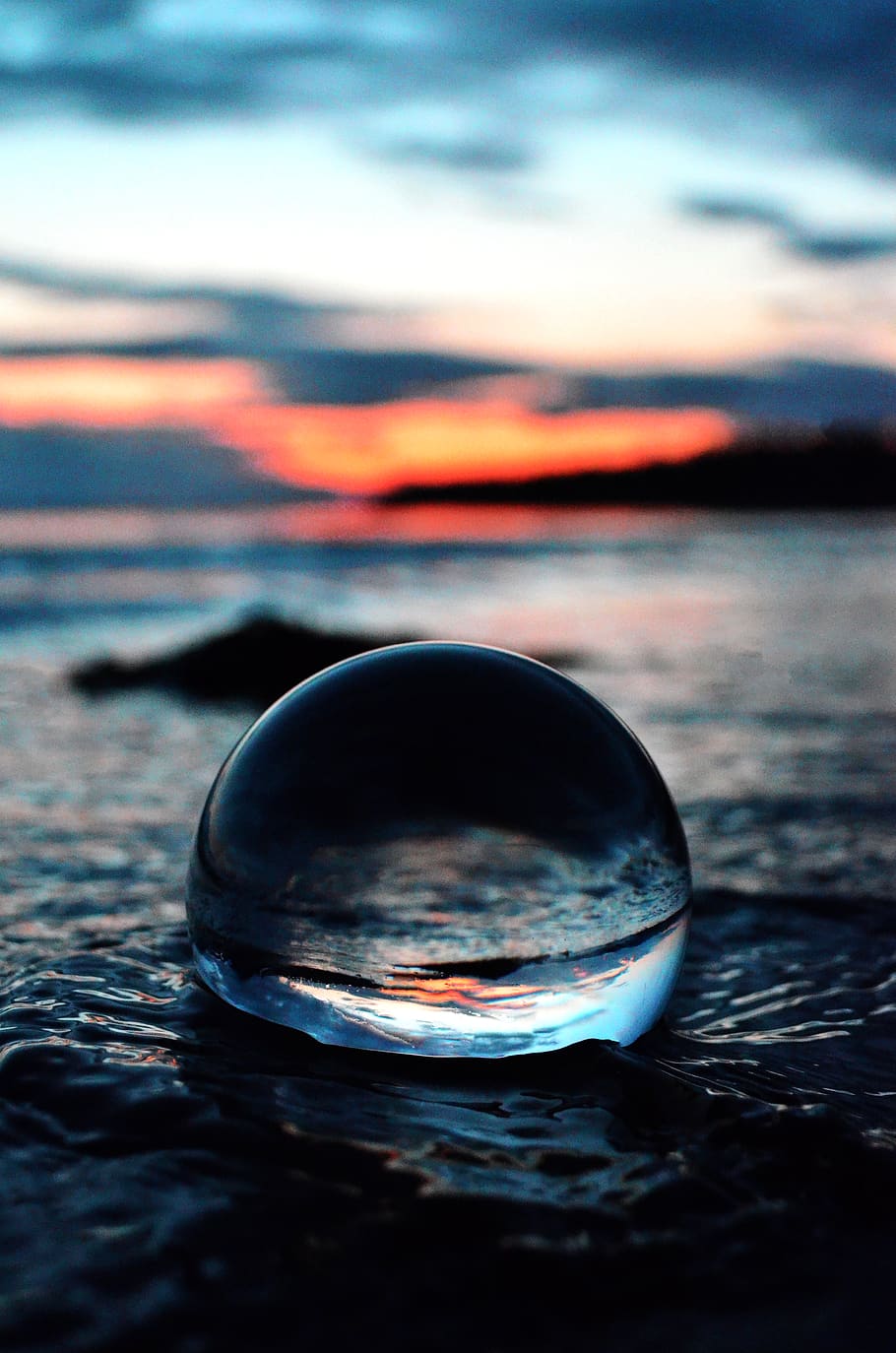 Clear Glass Ball on Shore in Tilt Shift Lens Photo, blurred background