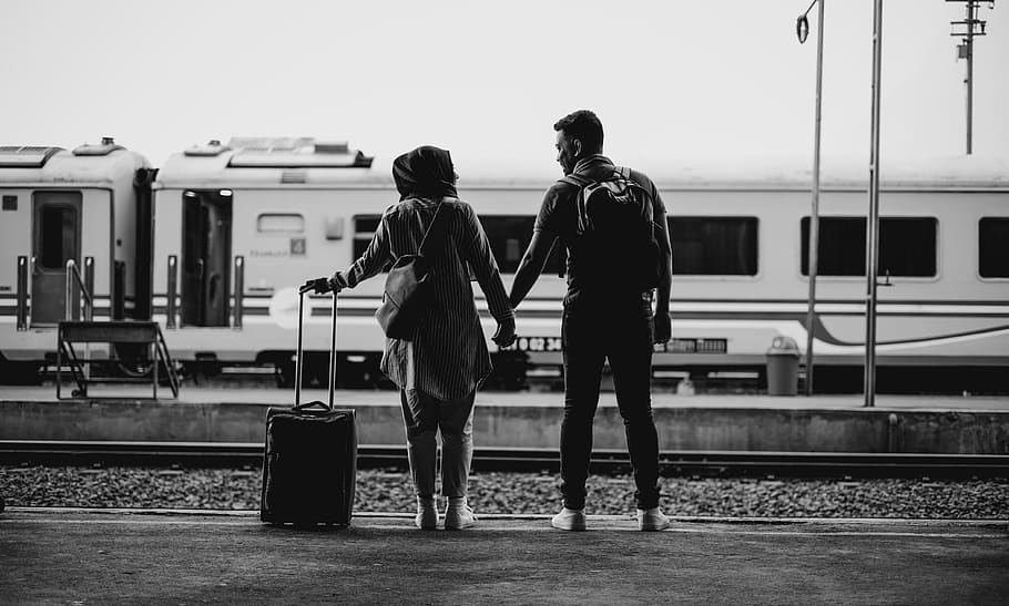 man and woman standing in front of white train, human, person
