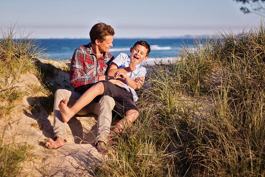 Man and Boy Sitting on Floor Near Body of Water, beach, child HD wallpaper