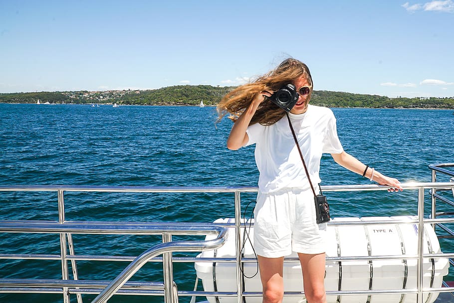 Woman Capturing Photo While Holding Hand Rails on Boat, beach HD wallpaper