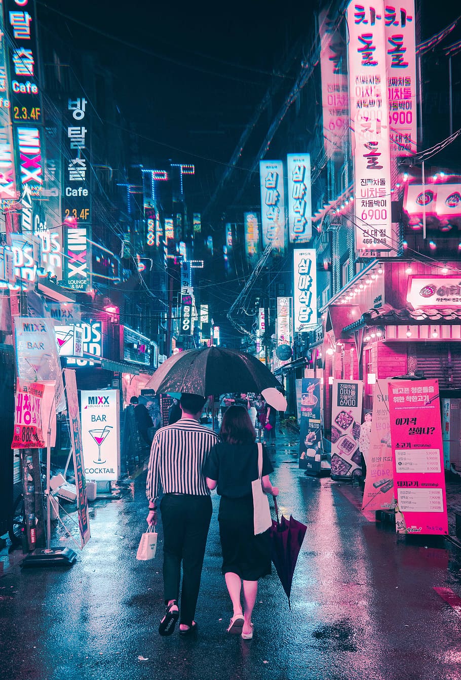 man holding umbrella beside woman while walking on street, cyberpunk