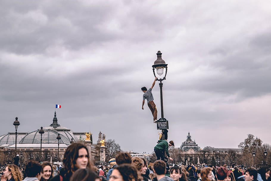 man on light tower, sky, architecture, crowd, large group of people HD wallpaper