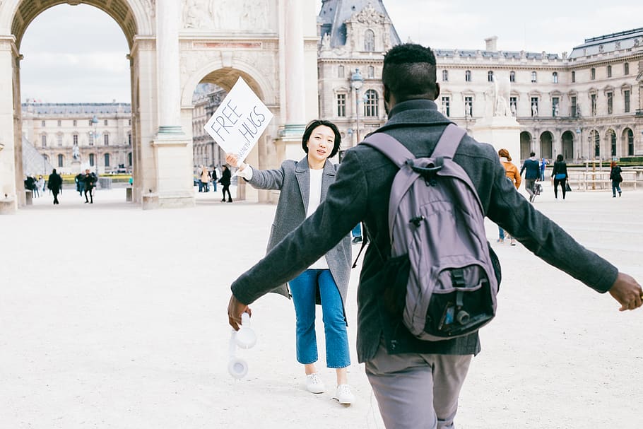 Man Walking Near to Woman Holding Signage, architecture, backpack HD wallpaper
