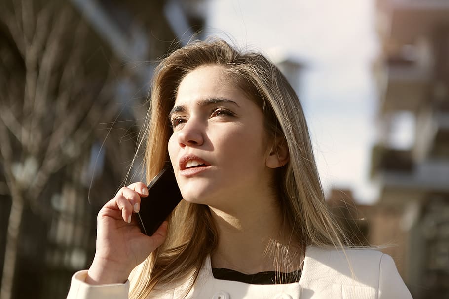 Selective Focus Photography of Woman Standing Wearing White Coat Holding Smartphone HD wallpaper