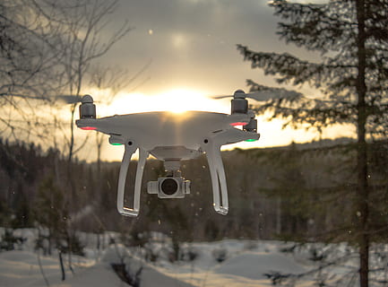 Photo of White Drone Quadcopter Flying Near Trees at Noontime HD wallpaper