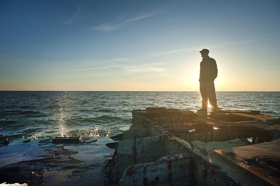 Silhouette Photo of Man Standing Near the Edge of Concrete Pavement HD wallpaper