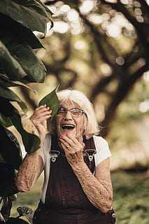 Selective Focus Photography of Woman Holding Green Leaf, beautiful HD wallpaper