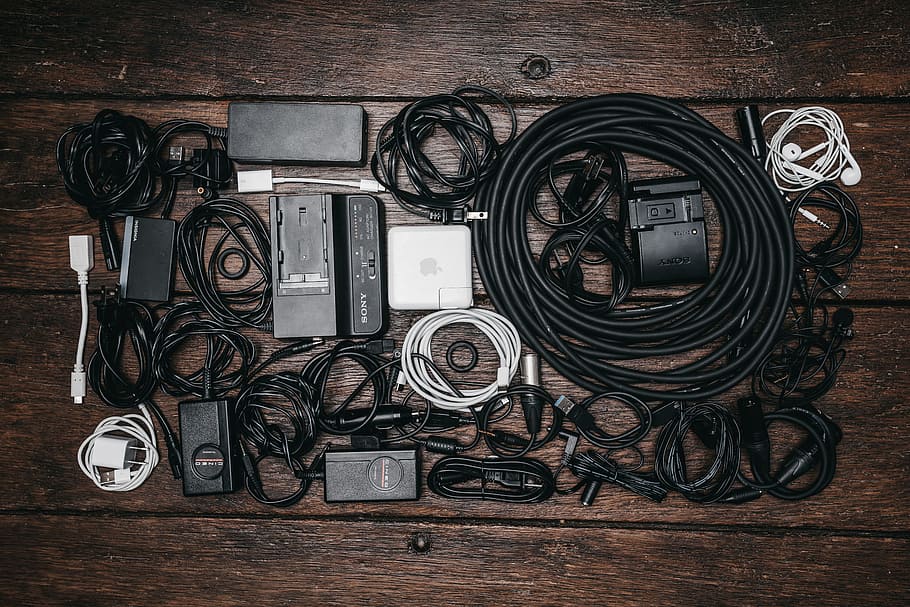 black cable lot and electronic devices on brown wooden surface HD wallpaper