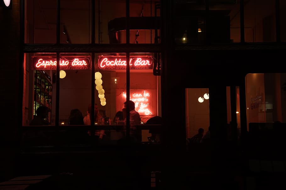 people sitting inside building with red neon signage, interior design