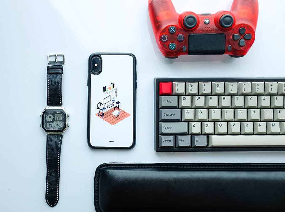 Flat Lay Photography of Dualshock 4 Beside Keyboard, Iphone X, and Digital Watch