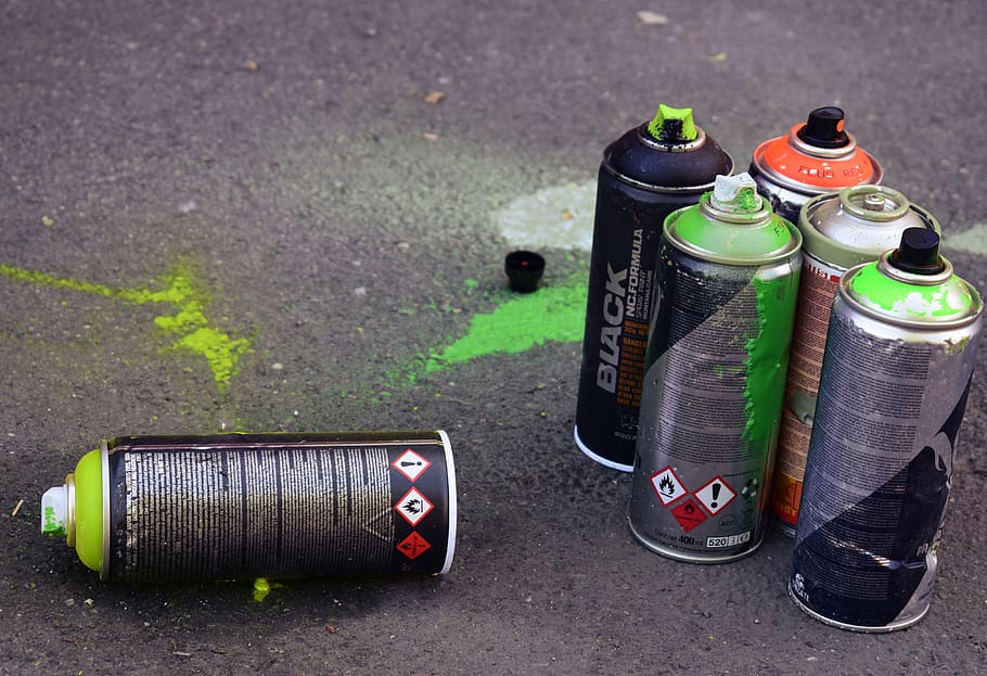 Used spray cans sitting on the ground., colors, street art, day